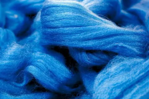 Leuchtend blaue Fasern, bereit für die Modal Herstellung. Ein Blick auf die Rohmaterialien, die für weiche Stoffe verwendet werden.
