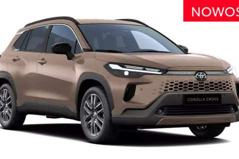 Nowy brązowy Toyota Corolla Cross Hybrid, z napisem "NOWOŚĆ" na czerwonym tle.