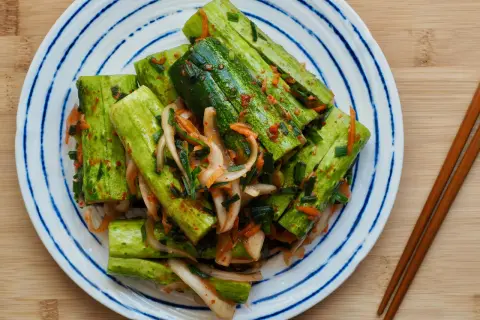 En tallrik med krispig gurka marinerad i en kryddig kimchi-sås, redo att avnjutas som ett läckert recept med kimchi.