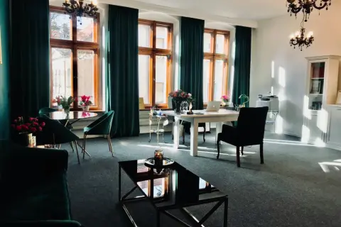 Eleganckie wnętrze biura z oknami, zasłonami, meblami i kwiatami.