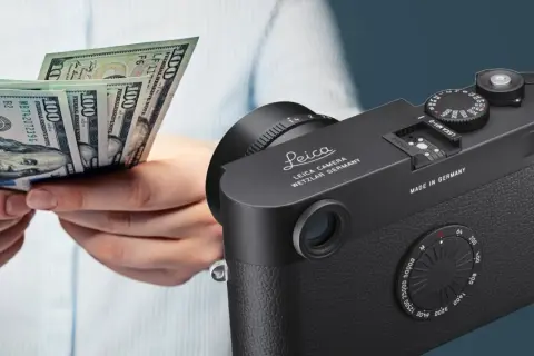 Mani che contano banconote da 100 dollari accanto a una fotocamera Leica, simbolo di qualità e investimento.