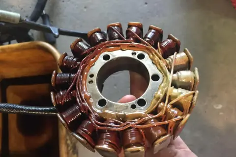 El estator de una moto, con sus bobinas de cobre recubiertas de barniz, listo para generar energía.