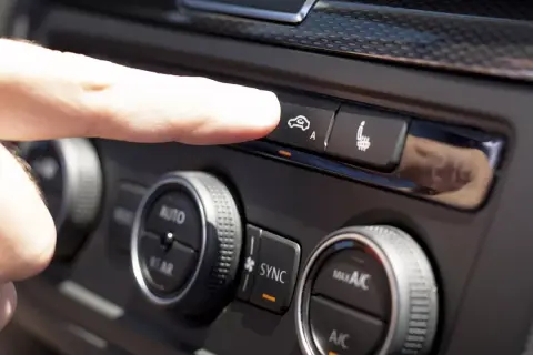 Finger trycker på knappen för acc bilens klimatanläggning.