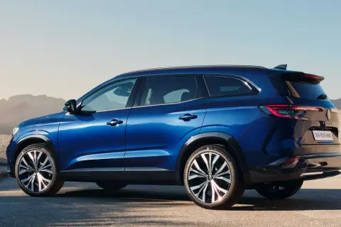 Błękitny Renault Espace 2024 z eleganckimi felgami stoi na tle pustynnego krajobrazu.