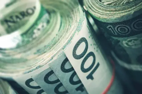 Zwijane banknoty 100 zł, symbolizujące fundusz rezerwy demograficznej, gotowe na przyszłe wyzwania.