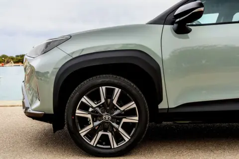 Zbliżenie na zielony Toyota Yaris Cross z czarnymi felgami. Idealny do miasta, niskie spalanie.