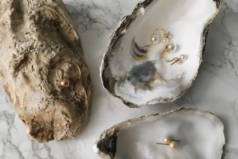 Perlenschmuck in Austernschalen. Ein Ring und Ohrringe, die an 19 Jahre verheiratet erinnern.