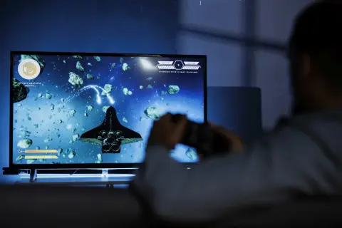 Gracz steruje statkiem kosmicznym w grze vdu, unikając asteroid.