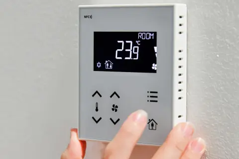 Termostat z wyświetlaczem pokazuje 23.9°C. Widoczne są oznaczenia na pompie co, ikony i przyciski.