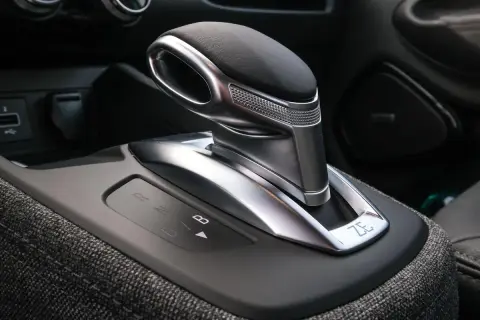 Levier de vitesse d'une b boite auto moderne, avec indicateurs lumineux R, N, D, B. Le design est futuriste et élégant.