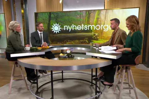 Ulrika Elvgren och kollegor diskuterar nyheter vid ett runt bord.