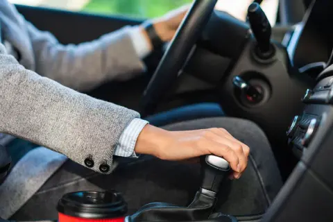 Main d'une personne changeant de vitesse dans une voiture, prêt pour son permis b78.