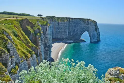 Falaises verdoyantes et arche rocheuse emblématique à Étretat, un paysage normand à couper le souffle, entre Fécamp et le littoral.
