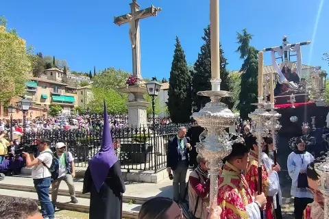 Procesiones Semana Santa Viernes Santo en Granada. Nazarenos con túnicas moradas y pasos procesionales iluminados por velas.