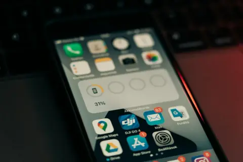 Ekran telefonu z ikonami aplikacji, w tym Google Maps i App Store. Może to być początek przygody z swift programowanie.