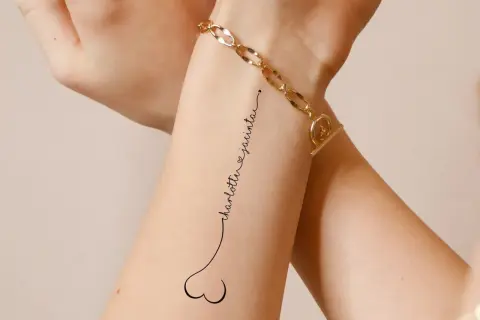 Ein dezentes Tattoo mit den Namen "Charlotte & Jacinta" in geschwungener Schrift, verbunden mit einem kleinen Herz.