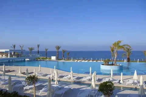 Basen i plaża w King Evelthon Beach Hotel and Resort. Opinie gości potwierdzają piękno tego miejsca.