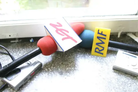 Mikrofony z logotypami RMF FM i Zet, rejestrator dźwięku i odtwarzacz MP3 na parapecie.