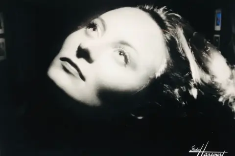 Portrait dramatique d'une femme, éclairée par le bas, évoquant l'histoire du Studio Harcourt.