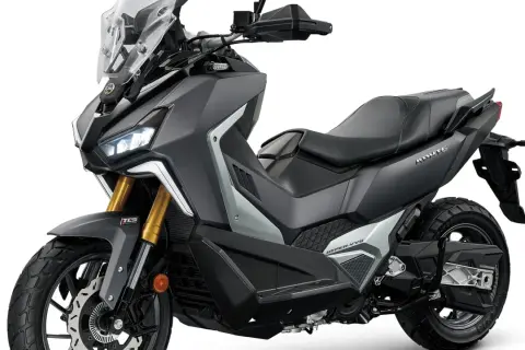 Scooter todo terreno gris oscuro con detalles plateados, asiento negro y parabrisas alto. ¡Listo para la aventura!
