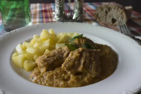 Sabrosa carne guisada con verduras y patatas, servida en un plato blanco.