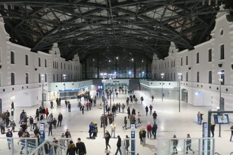 Nowoczesny dworzec Łódź Fabryczna, idealny punkt startowy, by zobaczyć co warto zobaczyć w Łodzi w jeden dzień. Tłumy podróżnych pod imponującym dachem.