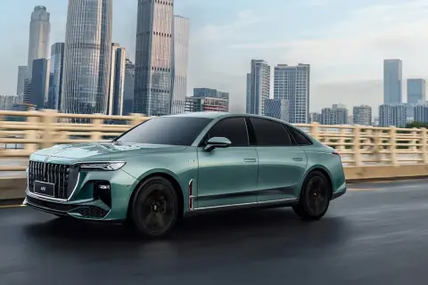 Elegancki, zielony Hongqi H9 na tle drapaczy chmur. Sprawdź, jaka jest jego hongqi h9 cena i poczuj luksus.