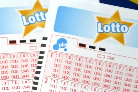 Kupony Lotto z polami do zaznaczenia liczb. Tabela wygranych w keno jest częścią gry.