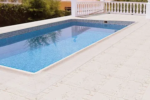 Piscina con suelos para piscinas que no quemen, de tonos claros y textura agradable.