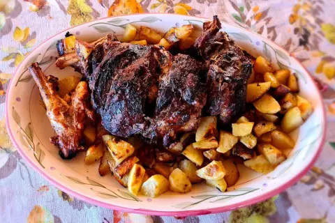 Un succulento agnello al forno con patate dorate, un piatto che profuma di tradizione e festa.