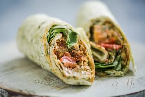 Pyszna tortilla z kurczakiem, świeżymi warzywami i kremowym sosem, idealna na szybki lunch.