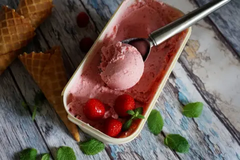Jak zrobić lody truskawkowe? Pyszne, domowe lody z truskawkami i miętą, gotowe do podania w wafelkach.