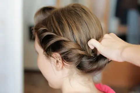 Manos expertas crean peinados trenzas boda, un recogido elegante y romántico para un día especial.