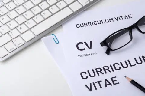 Klawiatura, okulary i dokumenty CV. Zastanawiasz się, gdzie w cv wpisać prawo jazdy? Najlepiej w sekcji "Umiejętności" lub "Dodatkowe informacje".