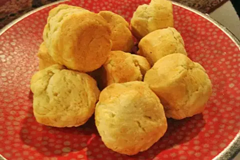 En hög med nybakade scones på en röd tallrik. Perfekt för ett mysigt fika med detta scones recept.