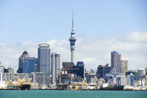 Skyline de Auckland, Nueva Zelanda, con la Sky Tower y barcos en el puerto. ¡Un destino ideal cuando viajar a Nueva Zelanda!