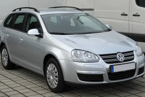 Srebrny Volkswagen Golf 5 Variant z relingami dachowymi, zaparkowany na kostce brukowej.