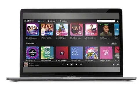 Laptop z interfejsem Amazon Music Unlimited. Widoczne playlisty: "All Hits UK", "Pop Right Now", "My Discovery Mix" i "Feel-Good 00s Hits".