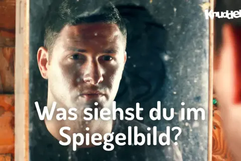 Ein Mann blickt in einen Spiegel und fragt sich, was er sieht. Ist es der Weg zum Erfolg im Leben?