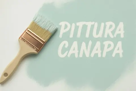 Pennello con calce a pennello che crea la scritta "PITTURA CANAPA" su una superficie chiara.