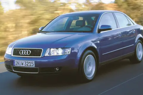 Niebieskie audi a4 b6 w ruchu, z rozmytym tłem drzew i drogi.