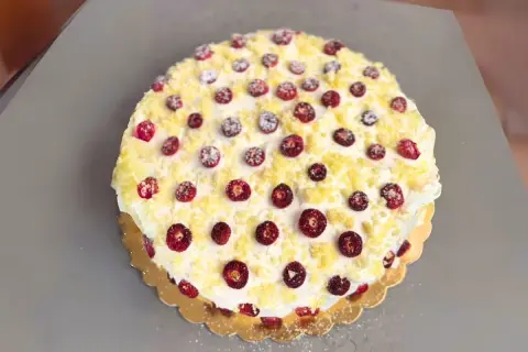 Torta pan di spagna decorata con panna, fragoline di bosco e briciole di pan di spagna. Un dolce invitante e colorato.