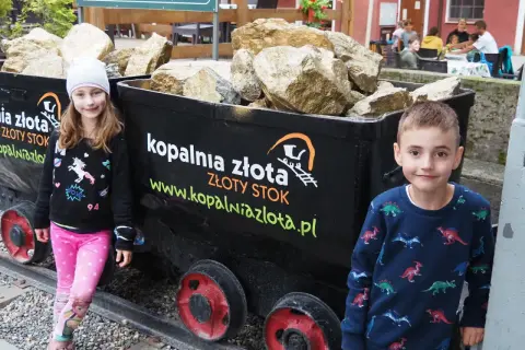 Dzieci przy wagonikach z "złotem" w Kopalni Złota w Złotym Stoku. Atrakcje dla całej rodziny.