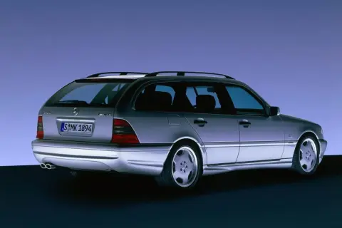 Srebrny Mercedes C klasa 2000 kombi z felgami AMG, widziany z tyłu, na tle niebieskiego gradientu.