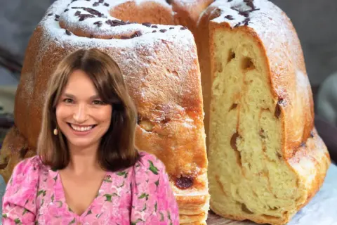 Uśmiechnięta kobieta w kwiecistej sukience obok puszystej, wilgotnej babki drożdżowej posypanej cukrem pudrem i czekoladą.