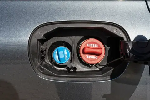 Dwa korki wlewu paliwa: czerwony z napisem DIESEL i niebieski z napisem AdBlue. Kluczowe dla systemu common rail.