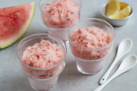 Erfrischendes Wassermelonen-Shave-Ice-Rezept in Gläsern, garniert mit Zitronenspalten und Wassermelone. Perfekt für heiße Tage!