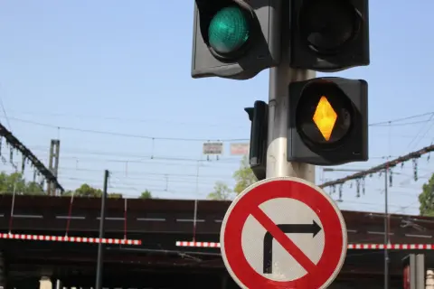 Feux orange clignotant sur un passage à niveau. Le panneau "interdit de tourner à droite" est visible.