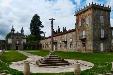 Pazos en Galicia: un cruceiro se alza en el patio de un complejo señorial con torreón y capilla.
