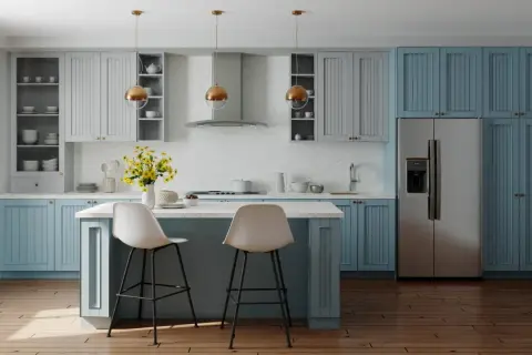 Eleganti cucine bicolore con basi blu e pensili grigi, isola centrale con sgabelli e un mazzo di fiori gialli.